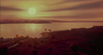 Movie still from “The Prince of Egypt” (1998), directed by Brenda Chapman – The sun is setting over the ocean with a view of the land; Extreme Wide shot, High angle