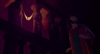 Movie still from “The Prince of Egypt” (1998), directed by Brenda Chapman – A man standing next to a pillar in a dark room; Wide shot, Low angle