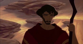 Movie still from “The Prince of Egypt” (1998), directed by Brenda Chapman – A man in a red shirt is standing in front of some mountains; Close Up shot, Overhead angle