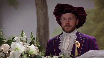 Movie still from “The Princess Diaries 2: Royal Engagement” (2004), directed by Garry Marshall – A man wearing a purple suit and a red hat; Medium shot, Over the shoulder angle