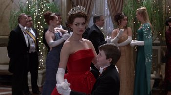 Movie still from “The Princess Diaries 2: Royal Engagement” (2004), directed by Garry Marshall – A woman in a red dress and a man in a tuxedo; Medium shot, Over the shoulder angle