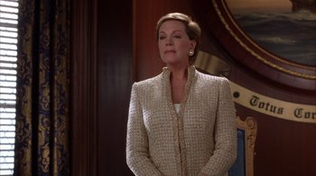 Movie still from “The Princess Diaries 2: Royal Engagement” (2004), directed by Garry Marshall – A woman standing in front of a mirror wearing a suit; Medium shot, Low angle