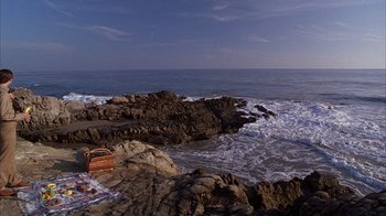Movie still from “The Princess Diaries 2: Royal Engagement” (2004), directed by Garry Marshall – A car is parked on the rocks near the ocean; Extreme Wide shot, High angle