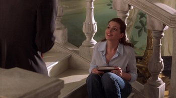 Movie still from “The Princess Diaries 2: Royal Engagement” (2004), directed by Garry Marshall – A woman sitting on the ground holding a book; Medium shot, High angle
