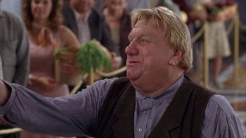 Movie still from “The Princess Diaries 2: Royal Engagement” (2004), directed by Garry Marshall – An older man with blonde hair and a smirking face; Close Up shot, Low angle