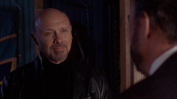 Movie still from “The Princess Diaries 2: Royal Engagement” (2004), directed by Garry Marshall – A man with a shaved head wearing a leather jacket; Close Up shot, Over the shoulder angle