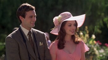 Movie still from “The Princess Diaries 2: Royal Engagement” (2004), directed by Garry Marshall – A man and a woman wearing a pink dress and a hat; Close Up shot, Over the shoulder angle