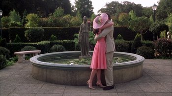 Movie still from “The Princess Diaries 2: Royal Engagement” (2004), directed by Garry Marshall – A man and a woman hugging in front of a fountain; Wide shot, High angle