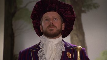 Movie still from “The Princess Diaries 2: Royal Engagement” (2004), directed by Garry Marshall – A man wearing a purple suit and a purple hat; Close Up shot, Low angle