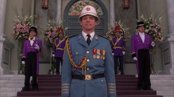 Movie still from “The Princess Diaries 2: Royal Engagement” (2004), directed by Garry Marshall – A man in a uniform standing in front of a building; Medium shot, Low angle