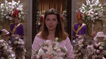 Movie still from “The Princess Diaries 2: Royal Engagement” (2004), directed by Garry Marshall – A woman holding a bouquet of flowers while standing in front of a group of people; Close Up shot, Over the shoulder angle