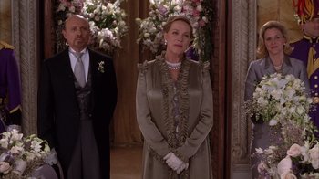 Movie still from “The Princess Diaries 2: Royal Engagement” (2004), directed by Garry Marshall – A man and a woman standing next to each other in front of flowers; Medium shot, Over the shoulder angle