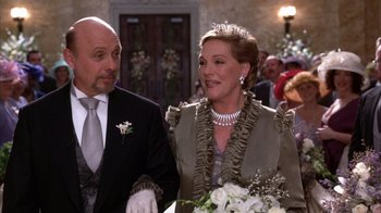 Movie still from “The Princess Diaries 2: Royal Engagement” (2004), directed by Garry Marshall – A man and a woman standing next to each other holding a bouquet; Medium shot, Low angle