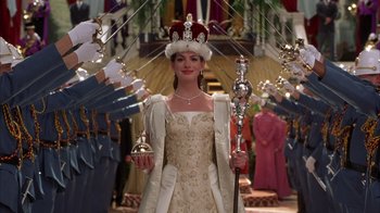 Movie still from “The Princess Diaries 2: Royal Engagement” (2004), directed by Garry Marshall – A woman in a crown holding a bell and a staff; Medium shot, Low angle
