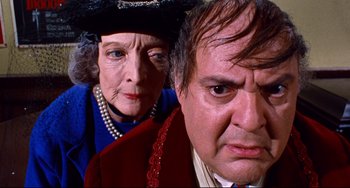 Movie still from “The Producers” (1967), directed by Mel Brooks – An older woman and a younger man are looking at the camera; Close Up shot, Low angle
