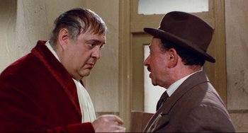 Movie still from “The Producers” (1967), directed by Mel Brooks – Two men in suits and hats talking to each other; Medium shot, Over the shoulder angle