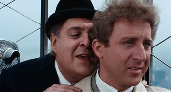 Movie still from “The Producers” (1967), directed by Mel Brooks – A man in a suit and a man in a top hat; Close Up shot, Over the shoulder angle