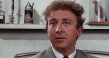 Movie still from “The Producers” (1967), directed by Mel Brooks – A person wearing a suit and tie; Close Up shot, Over the shoulder angle