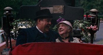 Movie still from “The Producers” (1967), directed by Mel Brooks – An older man and woman sitting next to each other; Medium shot, High angle