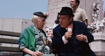 Movie still from “The Producers” (1967), directed by Mel Brooks – An old woman and a man sitting next to each other; Medium shot, Over the shoulder angle