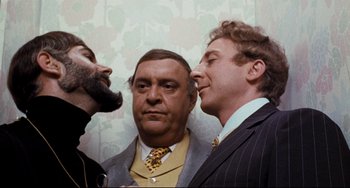 Movie still from “The Producers” (1967), directed by Mel Brooks – A group of men standing next to each other; Close Up shot, Over the shoulder angle