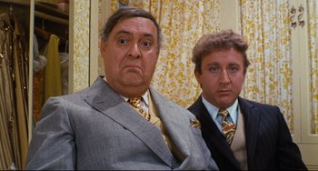 Movie still from “The Producers” (1967), directed by Mel Brooks – Two men in suits and ties posing for a picture; Close Up shot, High angle