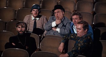 Movie still from “The Producers” (1967), directed by Mel Brooks – A group of people sitting in a theater; Medium shot, High angle