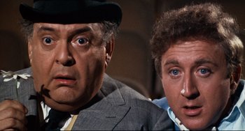Movie still from “The Producers” (1967), directed by Mel Brooks – A man and a woman are looking at the camera; Close Up shot, Low angle