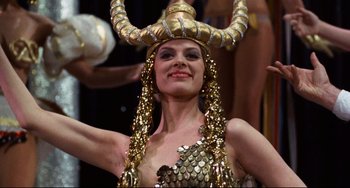 Movie still from “The Producers” (1967), directed by Mel Brooks – A woman wearing a gold costume and a gold hat; Medium shot, Low angle