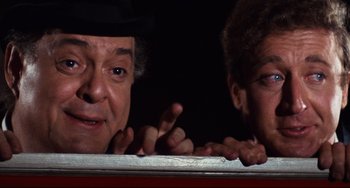 Movie still from “The Producers” (1967), directed by Mel Brooks – A man and a woman pointing at something in the dark; Close Up shot, Low angle