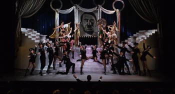 Movie still from “The Producers” (1967), directed by Mel Brooks – A group of men and women performing on a stage; Wide shot, High angle