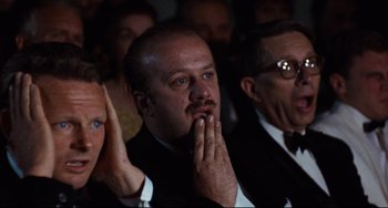 Movie still from “The Producers” (1967), directed by Mel Brooks – A group of men in suits and ties sitting next to each other; Close Up shot, High angle