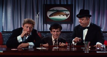 Movie still from “The Producers” (1967), directed by Mel Brooks – A group of men sitting at a table with drinks; Medium shot, High angle