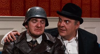 Movie still from “The Producers” (1967), directed by Mel Brooks – A couple of men sitting next to each other on top of a couch; Close Up shot, Over the shoulder angle