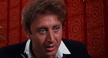 Movie still from “The Producers” (1967), directed by Mel Brooks – A person wearing a suit and tie; Close Up shot, Over the shoulder angle