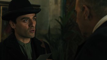 Movie still from “The Promise” (2016), directed by Terry George – A man wearing a hat talking to another man in a suit; Close Up shot, Over the shoulder angle