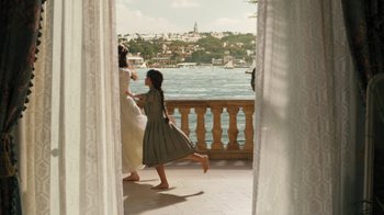 Movie still from “The Promise” (2016), directed by Terry George – Two women and a child walking on a balcony; Wide shot, High angle
