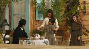 Movie still from “The Promise” (2016), directed by Terry George – Two women and a child are standing at a table; Wide shot, High angle