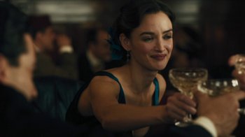 Movie still from “The Promise” (2016), directed by Terry George – A woman sitting at a table holding a wine glass; Close Up shot, Over the shoulder angle
