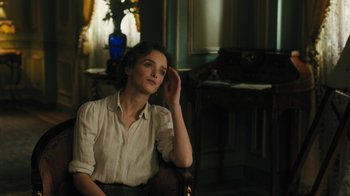 Movie still from “The Promise” (2016), directed by Terry George – A woman sitting in a chair in front of a window; Medium shot, Over the shoulder angle