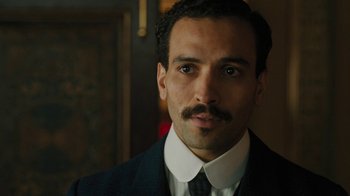 Movie still from “The Promise” (2016), directed by Terry George – A person wearing a suit and tie; Close Up shot, Low angle