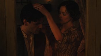 Movie still from “The Promise” (2016), directed by Terry George – A man and a woman are standing in a dark room; Close Up shot, Over the shoulder angle