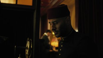 Movie still from “The Promise” (2016), directed by Terry George – A man wearing a fez looking at a mirror; Medium shot, Low angle