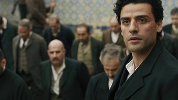 Movie still from “The Promise” (2016), directed by Terry George – A group of men in suits are standing in a line; Close Up shot, Over the shoulder angle
