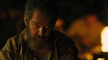 Movie still from “The Promise” (2016), directed by Terry George – A man with a beard is looking at the camera; Close Up shot, Over the shoulder angle