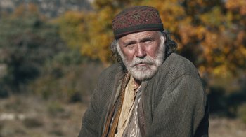 Movie still from “The Promise” (2016), directed by Terry George – An old man with a beard wearing a hat; Close Up shot, Low angle