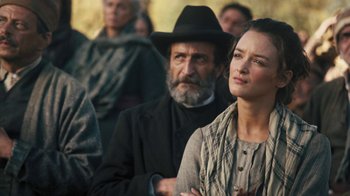 Movie still from “The Promise” (2016), directed by Terry George – A man and a woman are standing in front of a group of people; Close Up shot, Over the shoulder angle