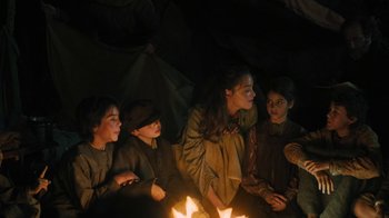 Movie still from “The Promise” (2016), directed by Terry George – A group of people sitting around a fire pit; Medium shot, High angle