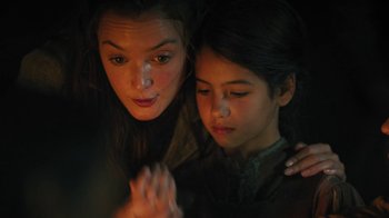 Movie still from “The Promise” (2016), directed by Terry George – Two young women are praying together in a dark room; Close Up shot, Over the shoulder angle
