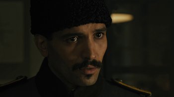 Movie still from “The Promise” (2016), directed by Terry George – A person with a mustache wearing a hat; Close Up shot, Low angle